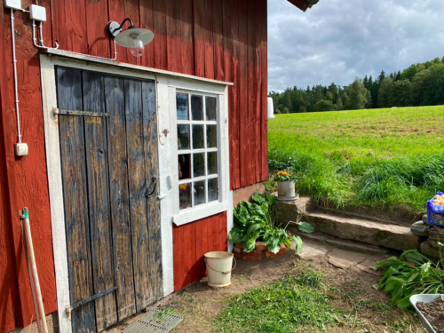 Rött trähus med ny utebelysning vid entrén