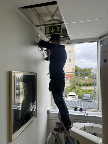 Installatör från Dilton Kyla drar kablar inför montering av luftvärmepump i kontorsmiljö