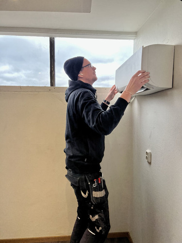 Tekniker från Dilton Kyla installerar en luft-luftvärmepump på en innervägg