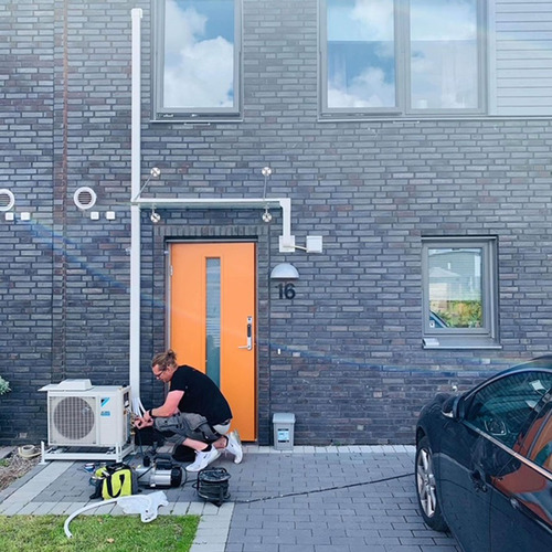 Tekniker från Dilton Kyla installerar utedel till luftvärmepump utanför radhus i Malmö