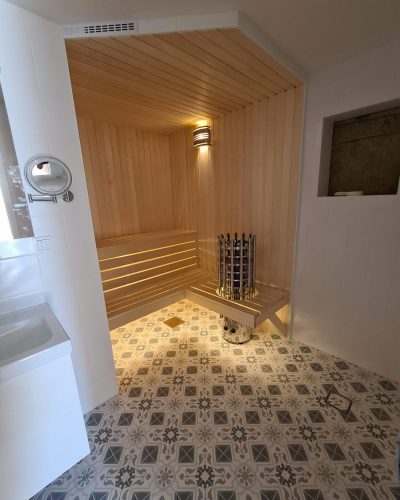 Badrumsrenovering med bastu i Täby – träpanel, belysning under lavarna och mönstrat klinkergolv