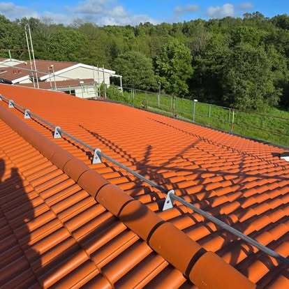 Nytt rött tegeltak med installerad taksäkerhet – lagt av Takgruppen Sverige AB.