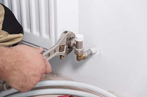 Installatör byter ventil på radiator – energieffektivisering av uppvärmning i Gävle.