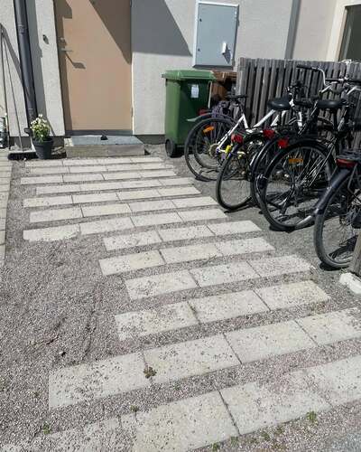 Plattlagd cykelparkering vid entré till bostadsområde