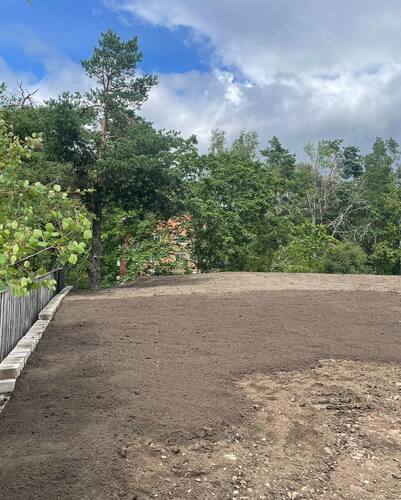 Nyplanerad tomt med utjämnad jord och stödmur – finplanering av trädgård i Vallentuna