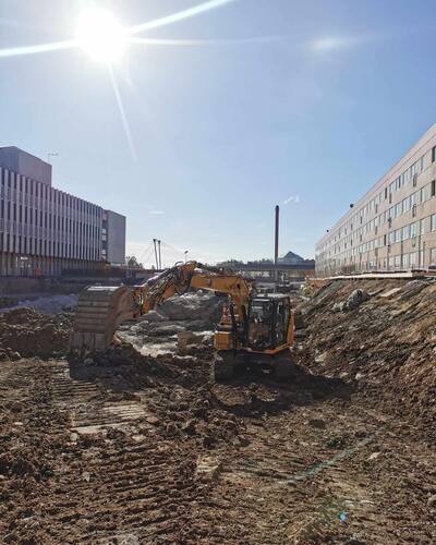 Grävmaskin i arbete med markschaktning på byggarbetsplats – anläggning av husgrund eller infrastruktur