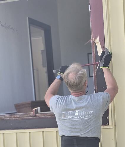 Fönstermontör från JL Fönster & Fasad demonterar gammalt fönster inför byte i villa