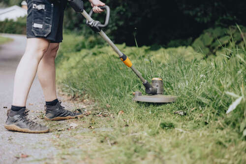 trimning av övervuxet gräs vid cykelbanan