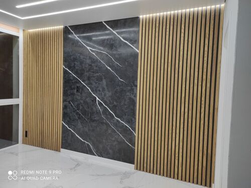 Elegant väggdesign med svart sten och vertikala träpaneler med LED-belysning