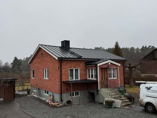 Bild på tegelvilla med nylagt plåttak i Stockholm