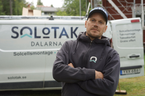Solotak-medarbetare framför firmabil med armarna i kors