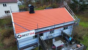 pågående takrenovering av röda betongpannor