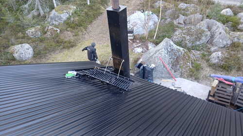 Plåttak med skorsten och säkerhetsräcke på taket