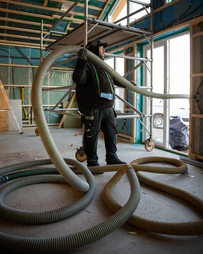 slangen som sprutar lösullsisolering på vinden