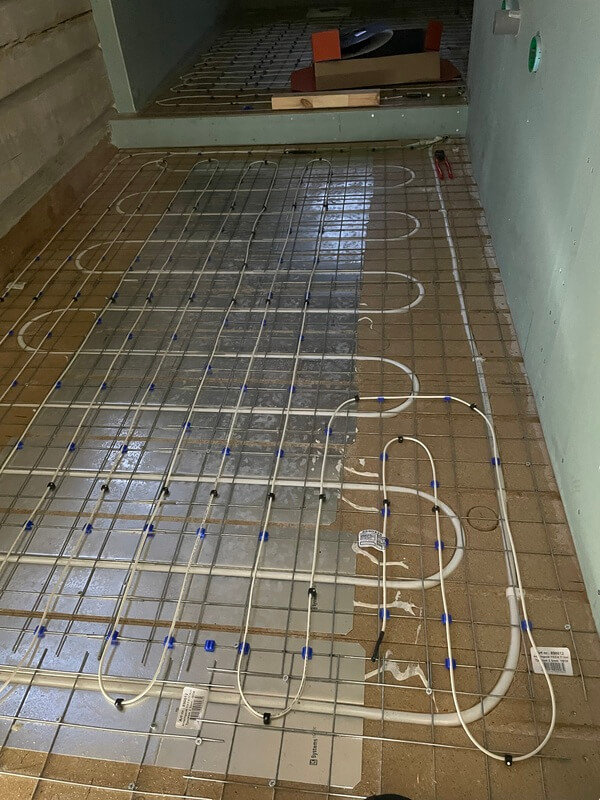 Golvvärme med elkablar ingjutna i kakelgolv under installation