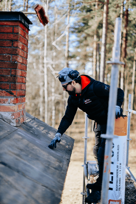 Takarbetare som utför arbete runt en skorsten