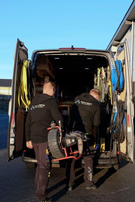 Medarbetare från Pipetech Spol & Relining lastar rörkameraslang i servicebil