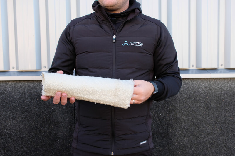 Medarbetare från Pipetech Spol & Relining håller reliningstrumpa