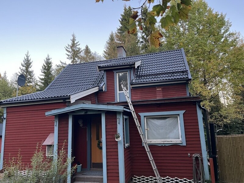 Rödmålat hus med nytt takmaterial sett från framsidan