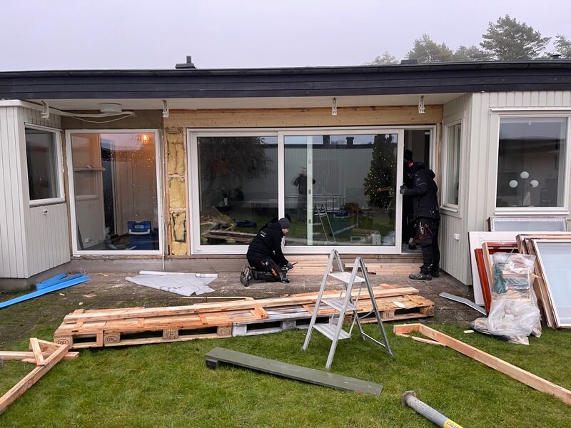 Montörer installerar nya skjutpartier på enplansvilla under pågående arbete