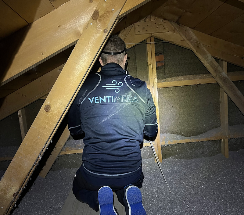 Tekniker i Ventimera-jacka arbetar på vind med isolering och takstolar