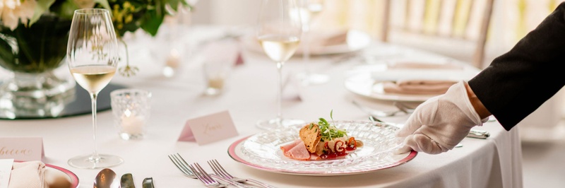 A private dining dish served on a white plate with cutlery next to it