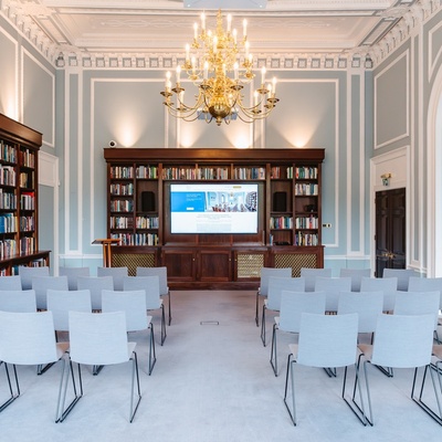 Theatre style in the Reading Room with floor to ceiling bookshelves, big windows and golden chandeliers