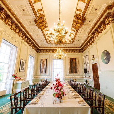 A row of chairs prepared at a dining table for a wedding dinner