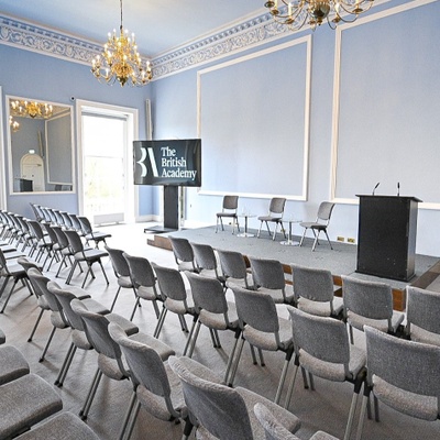 Conference with theatre style seating, stage and av facilities in a grand room with chandeliers and high ceilings