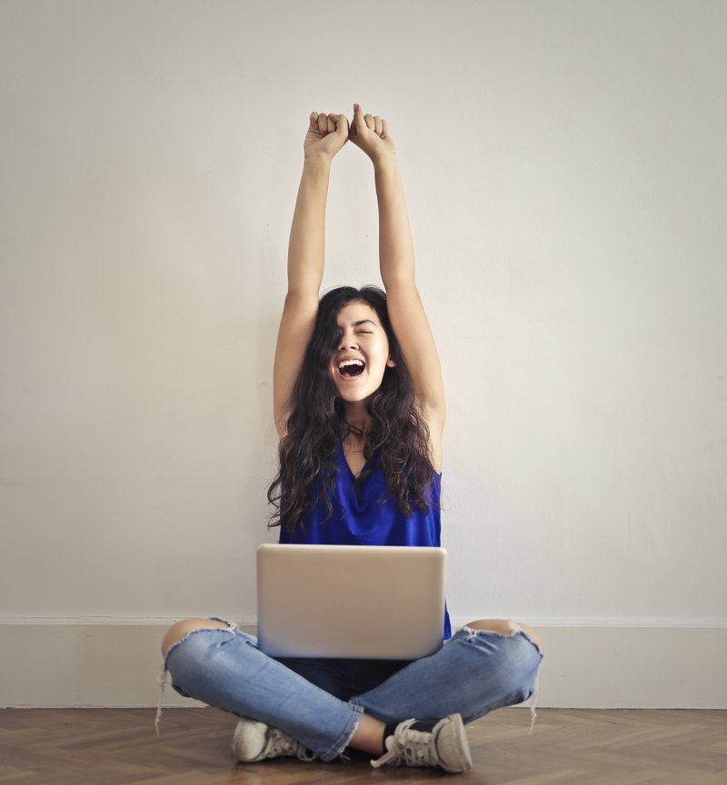 jubilant woman sitting with arms outstretched triumphantly