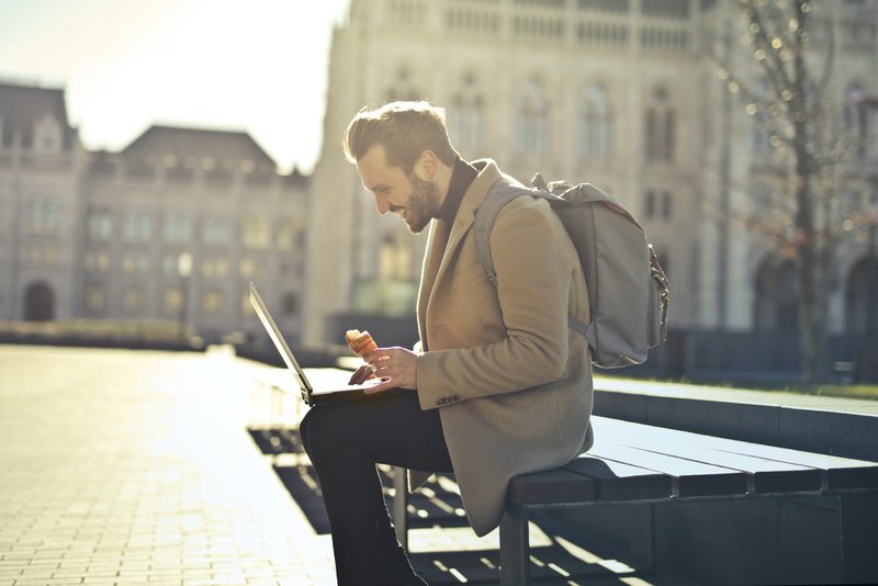 professional man sitting outside with laptop