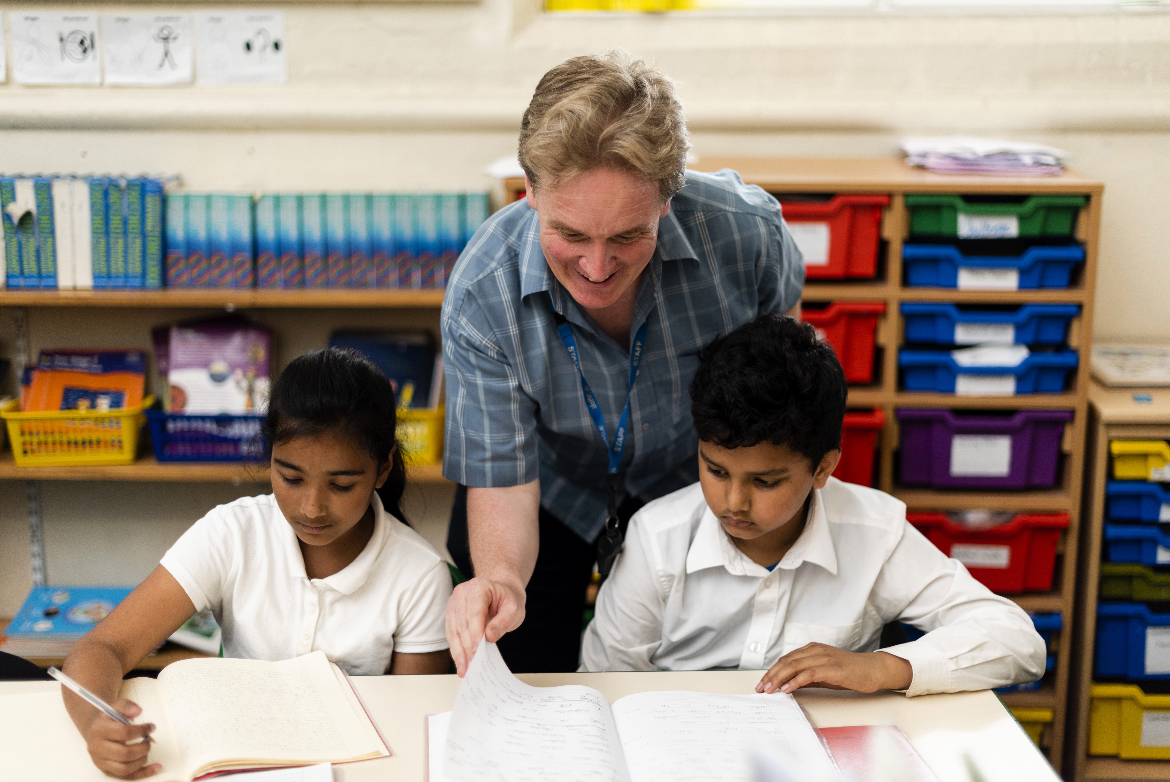 Randal Cremer_two children studying at desk with teacher
