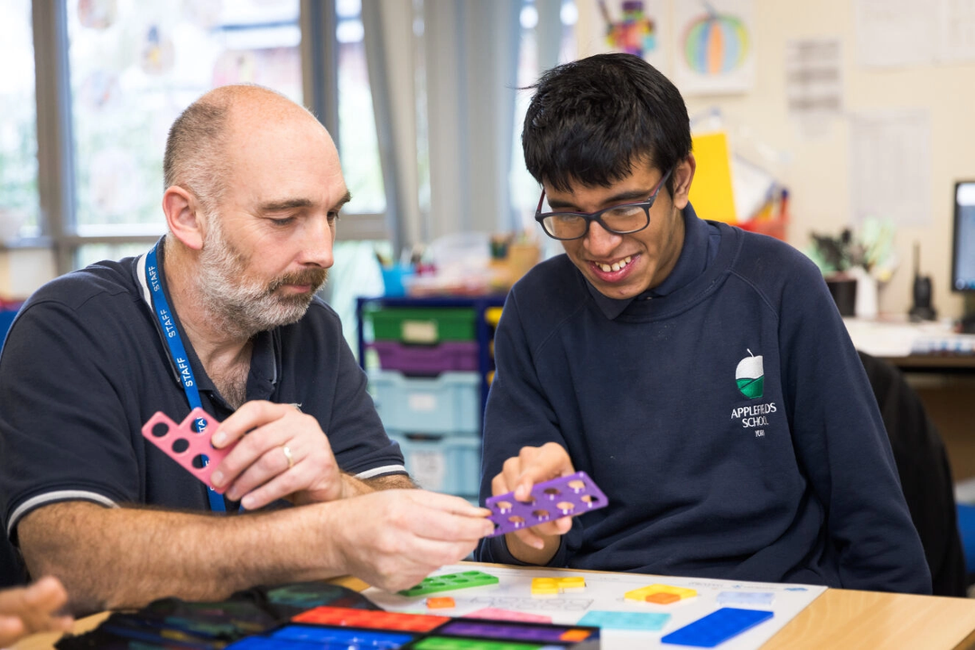 Photo of a teacher helping a pupil with maths