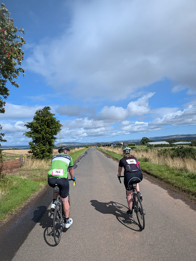 Accord team participating in Ride the North 2024 cycling event — cycling down a country road
