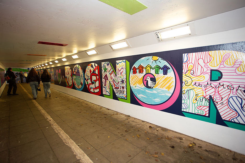 underpass with colourful graffiti that reads BOGNOR with different hand drawn images in the letters