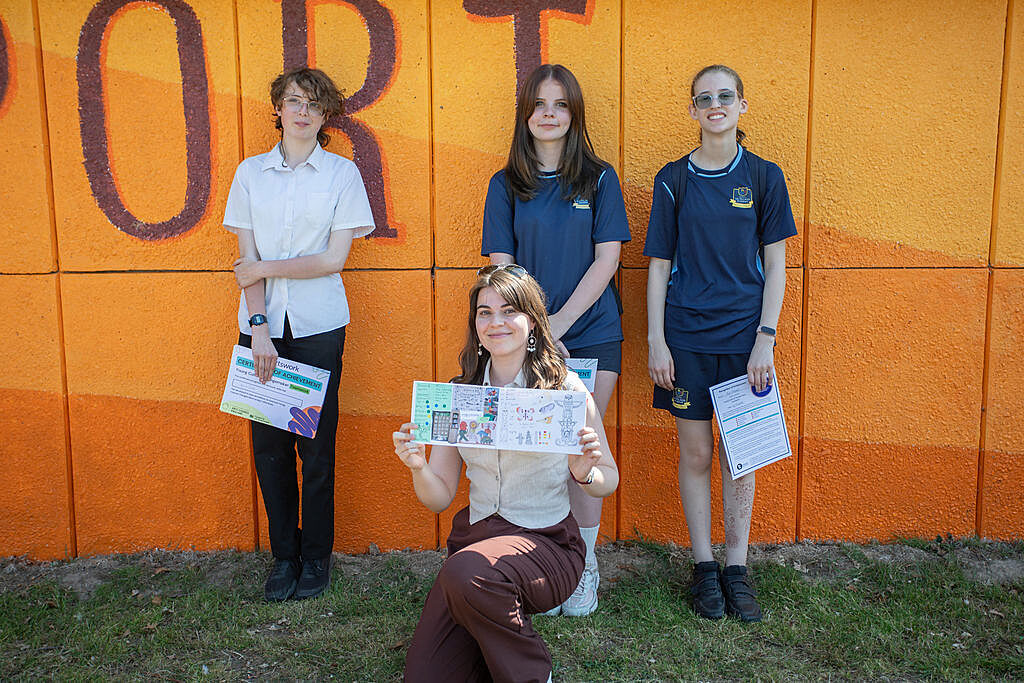 Four young people involved with the project show their digital badge achievements.