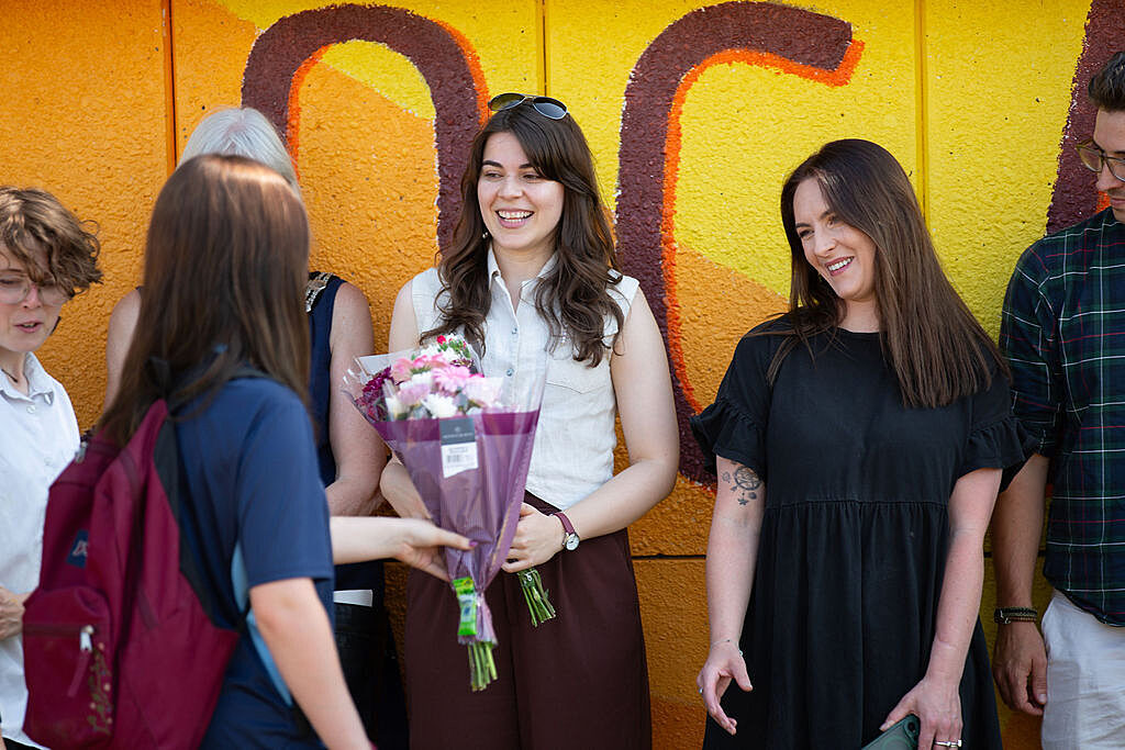 Artists working on the project are presented with flowers from young people.