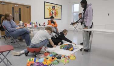 A group of young people are moving colourful decorated face masks to create a stop-motion animation film