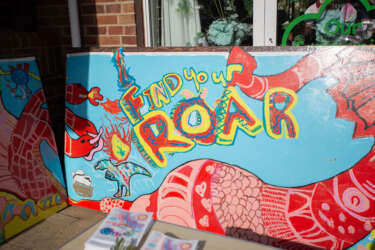a large colourful painted artwork with dragon designs that reads 'find your roar'