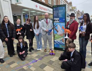 Young people, the artist and councillor that worked on the project together stand in front of the new wayfinding sign to celebrate the launch.