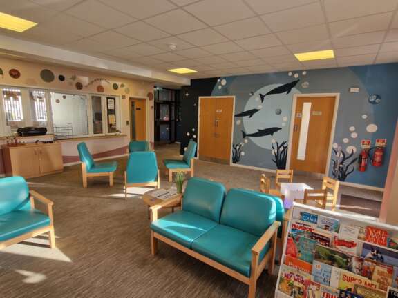 Mental health reception area with sea life and nature inspired murals on the walls