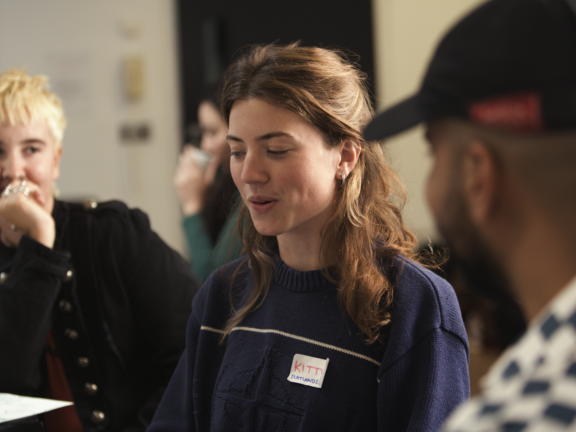 2 young consultants talk to a business owner - you can see the two young people's face but not the business owner