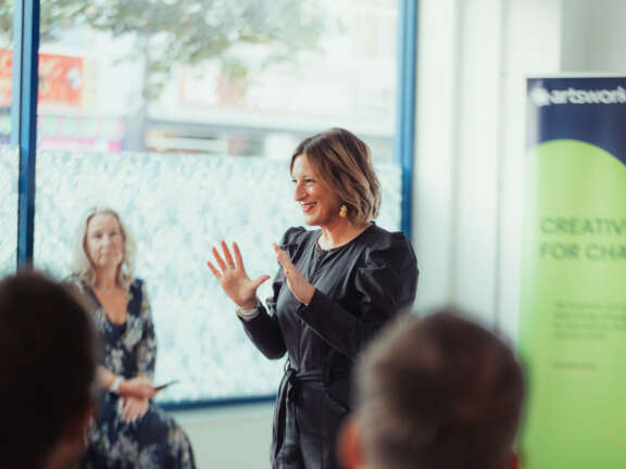 CEO of Portsmouth Creates, Gemma presents to a crowd of people.