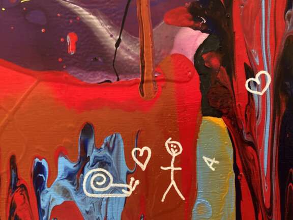 close up of paint pour artwork with a snail, stick man, 'A' and two hearts drawn on as signatures in white pen