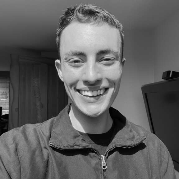 young person with short hair smiling at camera