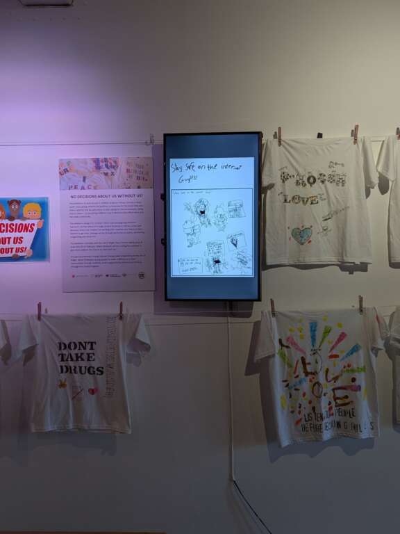 Exhibition of t-shirts designed by young people with various slogans including 'keep nature and earth safe' 'women's rights' 'don't take drugs'