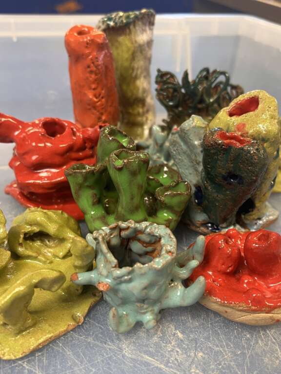 close up image of an array of abstract ceramic forms with brightly coloured glaze and lots of varying shapes and textures