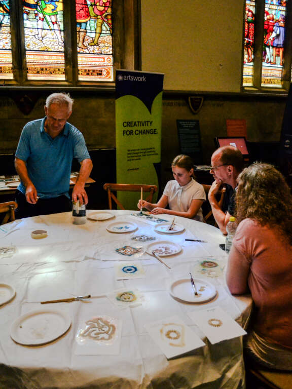 three adults and young person working in a creative round table