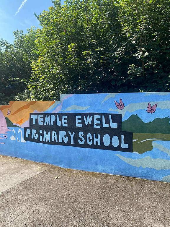 Colourful mural with stencilled text that says "Temple Ewell Primary School"