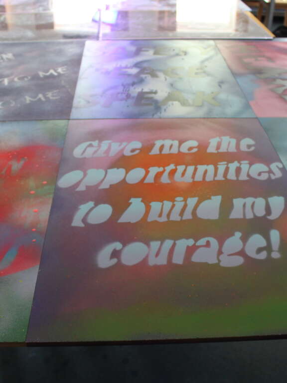 Spray painted artwork with text reading 'give me the opportunities to build my courage!' and 'love & understanding' and other text that isn't fully visible